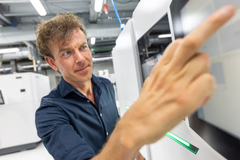 Engineer stelt een buildjob in op het bedieningsscherm van een SLS-printer
